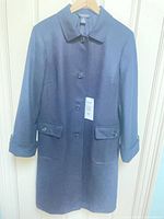 Front full view of navy single-breasted coat showing buttons, pockets and cuffs