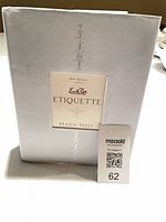 Front view of Emily Post's Etiquette book inside white slipcase showing title window and design