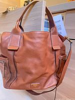 Front view showing overall shape, handles, side zip pockets