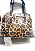 Front view of leopard print Kate Spade handbag with black handles