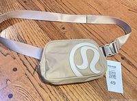 Full view of Lululemon belt bag with strap extended on wood surface