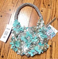 Full view of handbag showing sequin design and handle