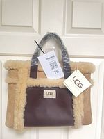 Front view showing brown leather panel with UGG patch and shearling trim