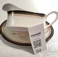 Side view of gravy boat resting on underplate showing pattern and trim
