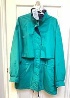 Full front view of green Eddie Bauer raincoat on hanger