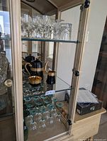 Cabinet showing coffee service and teal stemware