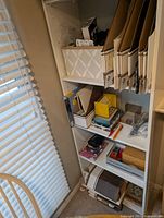 Full bookshelf section with assorted office supplies, storage basket, hanging files