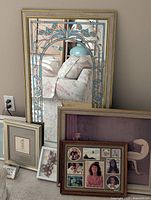 All items leaning against wall – mirror, prints, frames