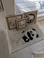 Three framed elephant tapestries and panda rug