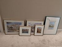 All five framed prints leaning against wall showing relative sizes and frame styles