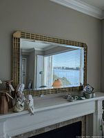 Front view of rectangular brass-framed mirror on wall