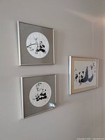 All three framed panda artworks displayed on wall