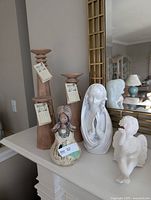 Steven Kaye candleholders with angel figurines on mantel