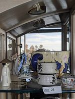 Shelf view showing planter, bowls, bell, trinket box, figure