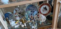 Overall view of shelf with cat plates and assorted figurines