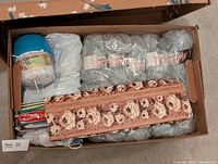 Box containing sealed yarn pack, multicolour yarn tub, roll-up needle case