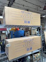 Two sealed Optimus STS 800 speaker cartons on shelf
