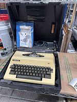 Typewriter inside open case with accessories visible