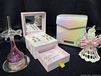 Group shot showing all items: jewelry set in open box, purple glass perfume bottle, iridescent storage case, white lattice perfume bottle