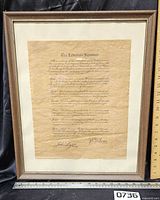Full view of framed document with ruler for size reference