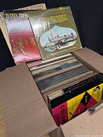 Open box filled with upright LP records, top jackets Tchaikovsky and unidentified title visible