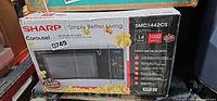 Front of sealed box showing Sharp Carousel microwave model SMC1442CS