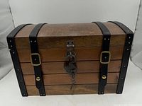 Front view of wooden chest with straps and padlock