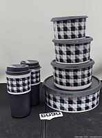 Full set showing two travel cups and stack of four plaid containers
