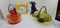 Group shot of all four items: clock, amberina swan dish, green glass basket, Labrador figurine
