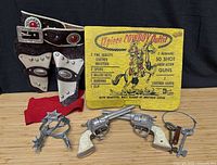 Overview showing holsters, spurs, keys, bandana, cap guns, box lid