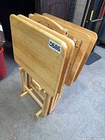 set of four folded solid wood tray tables in stand