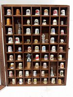 Front view of wood display case with thimbles