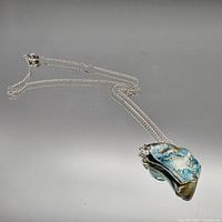 Full view of abalone pendant necklace laid out showing chain and pendant