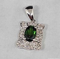 Front view showing green center stone, diamond accents, bail