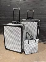 Three-piece Lauren by Ralph Lauren luggage set showing both suitcases extended and tote in front
