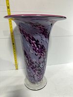 Full view of tall flared art glass vase beside tape measure showing 21 in height