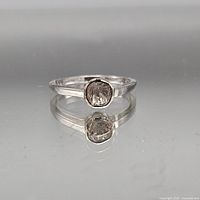Front view of sterling silver ring with bezel-set grey stone