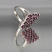 Side profile of sterling silver cluster ring showing red stones and band