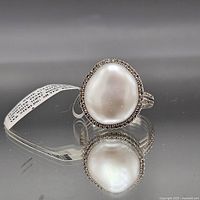 Top view of ring showing baroque pearl and topaz halo