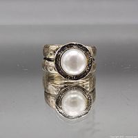 Front view showing pearl cabochon and bezel