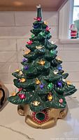Front view of ceramic Christmas tree with bird lights and gold base