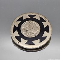 Front view showing Aztec calendar design and enamel pattern