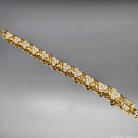 Full view of yellow gold-tone heart tennis bracelet