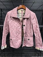 Full front view of mauve quilted Burberry Brit jacket on hanger