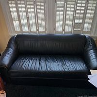 Front view of black leather sofa showing full form and seat