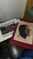Million Man March poster and Malcolm X poster side by side on floor