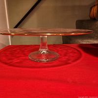 Side view of clear pressed glass pedestal cake stand