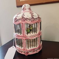Full view of porcelain birdcage on table