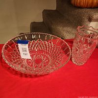 Shallow cut crystal bowl and vase on red cloth