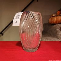 full view of clear crystal vase on red surface